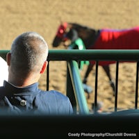 A racing fan peruses the track program at Churchill Downs